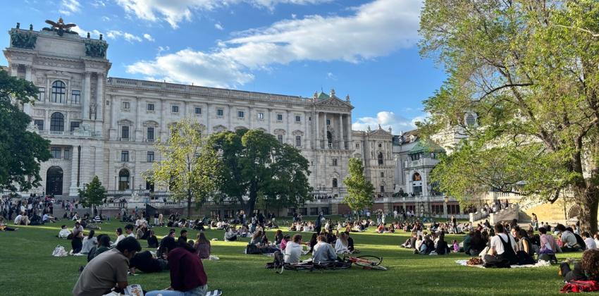 Students sit in the park on a sunny day in Vienna, Austria.
