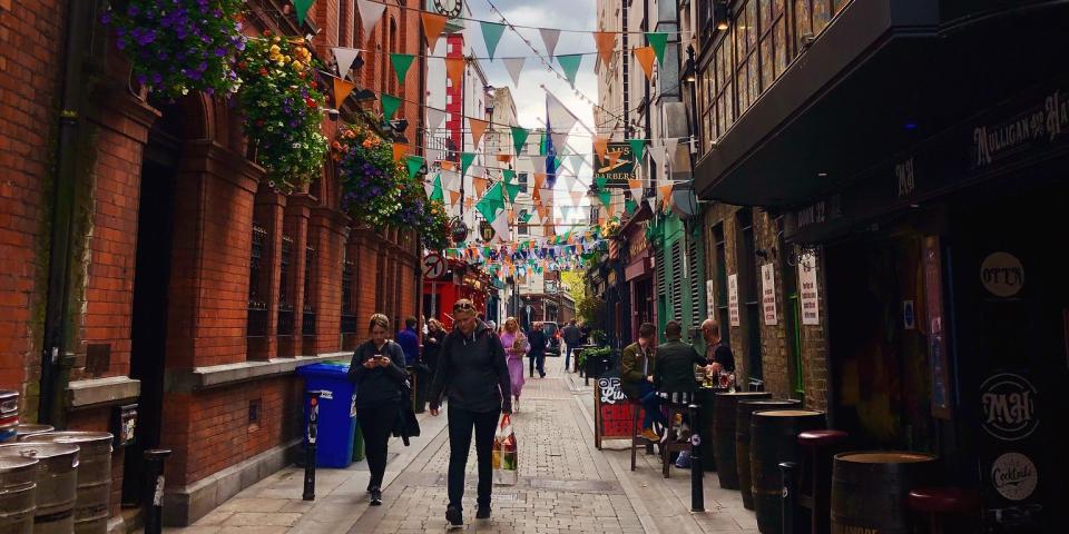 a street in Temple Bar lined with green and orange flags