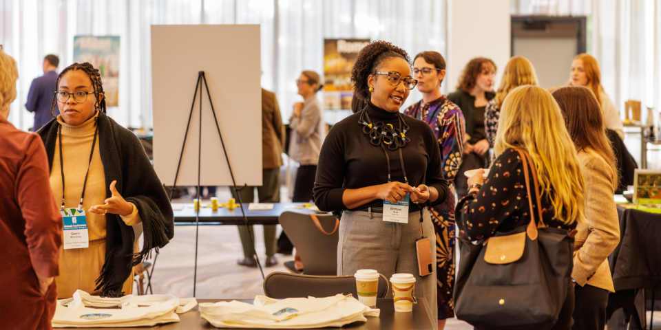 IES Abroad staff talking with participants at a conference.
